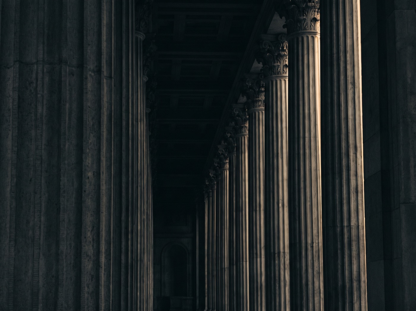 A colonnade of stone pillars lit by warm light
